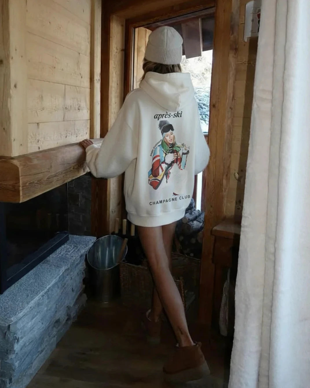 Person wearing a hoodie with a graphic design in a wooden interior setting