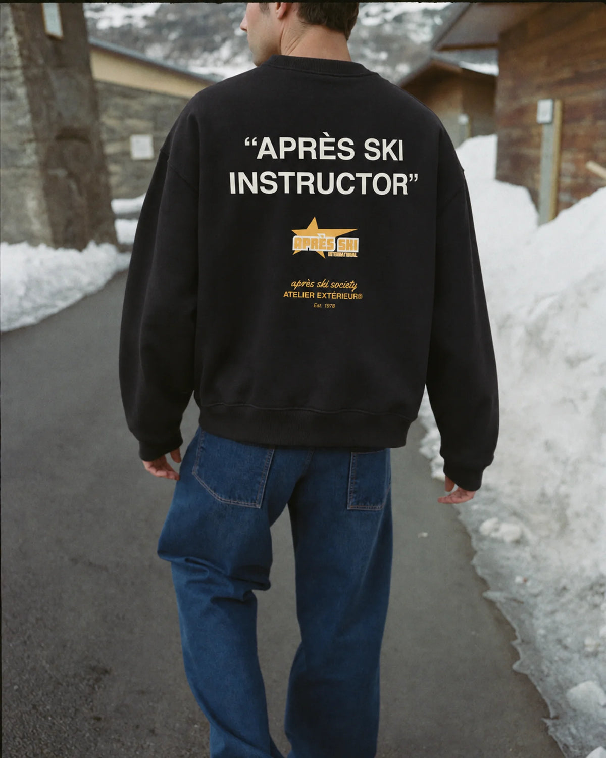 Man wearing the Après Ski Instructor Crewneck in black, on location
