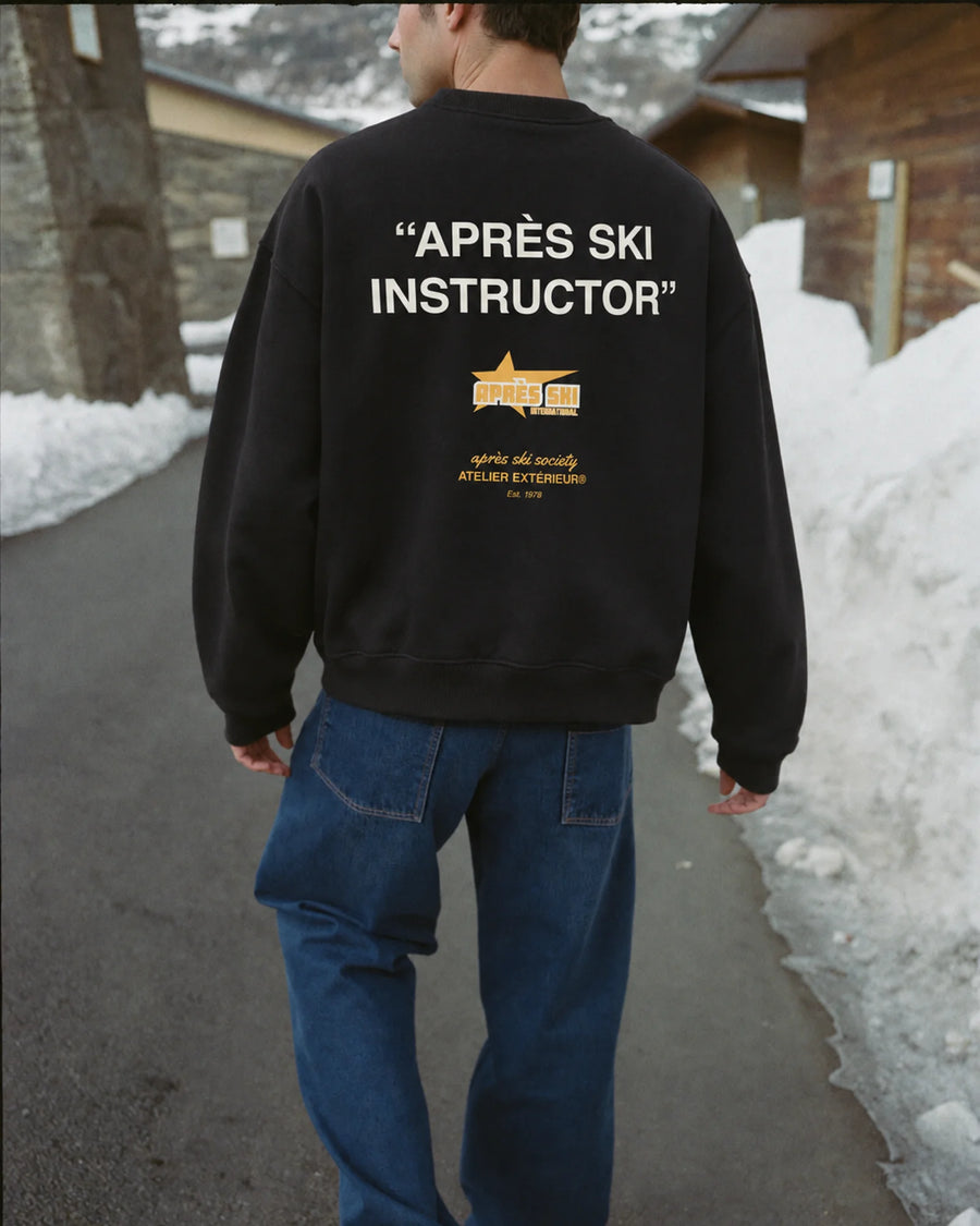 Man wearing the Après Ski Instructor Crewneck in black, on location