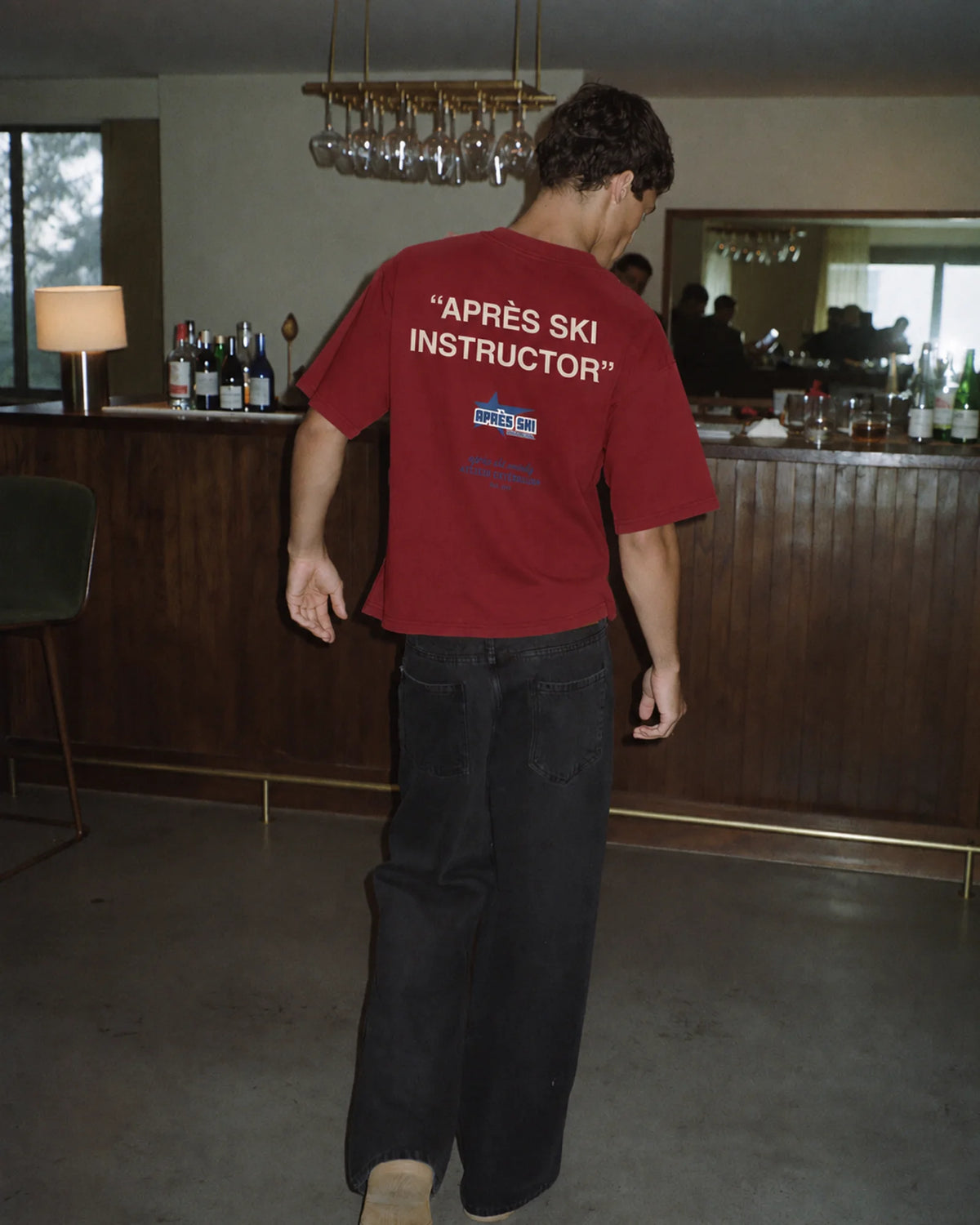 Man wearing the Après Ski Instructor Tee in red, on location