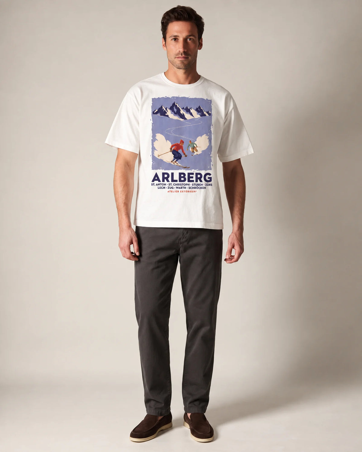 Model wearing the white Arlberg ski tee in a studio, front view