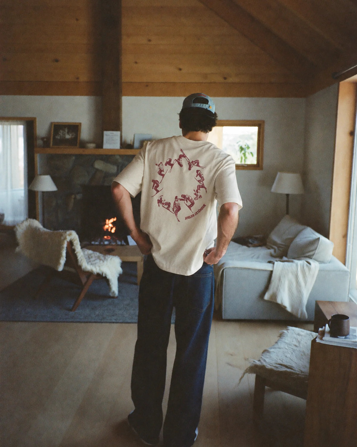 Man wearing the ecru Backflip tee outdoors, showing the back print