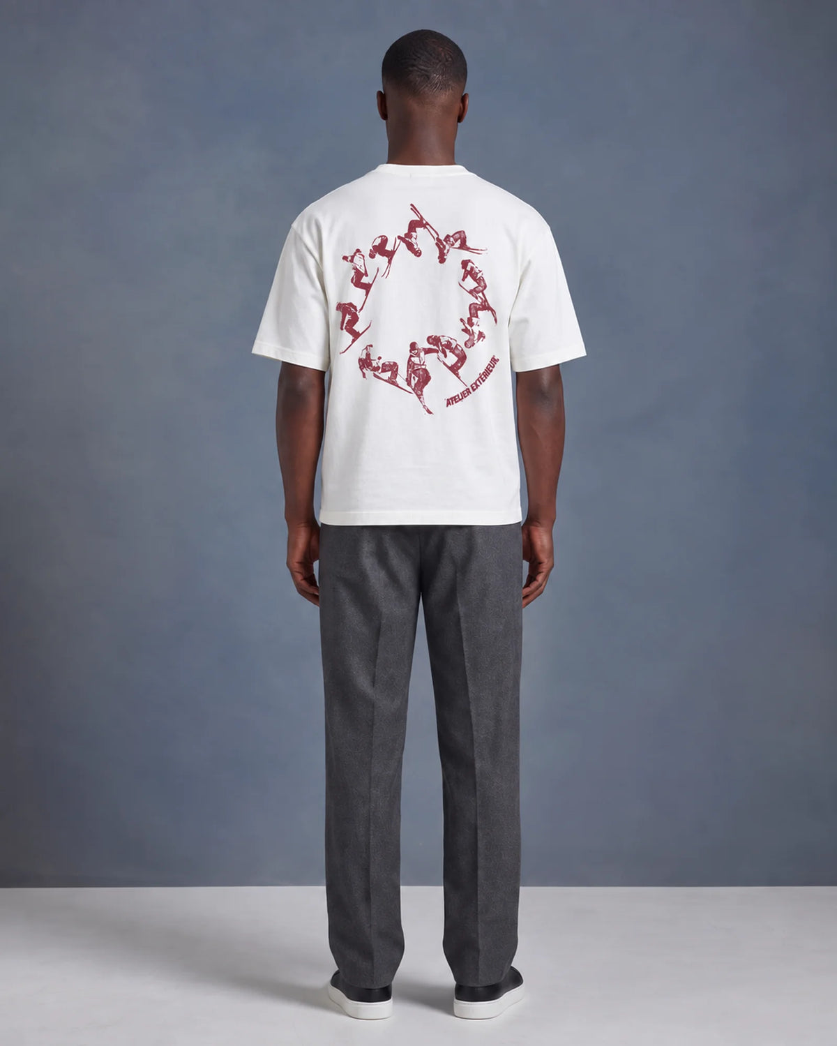 Model wearing the white Backflip tee in a studio, back view