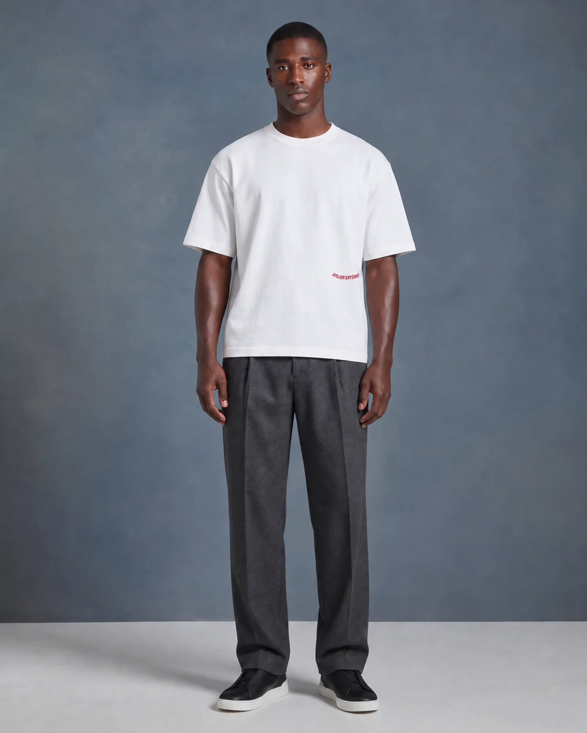 Model wearing the white Backflip tee in a studio, front view