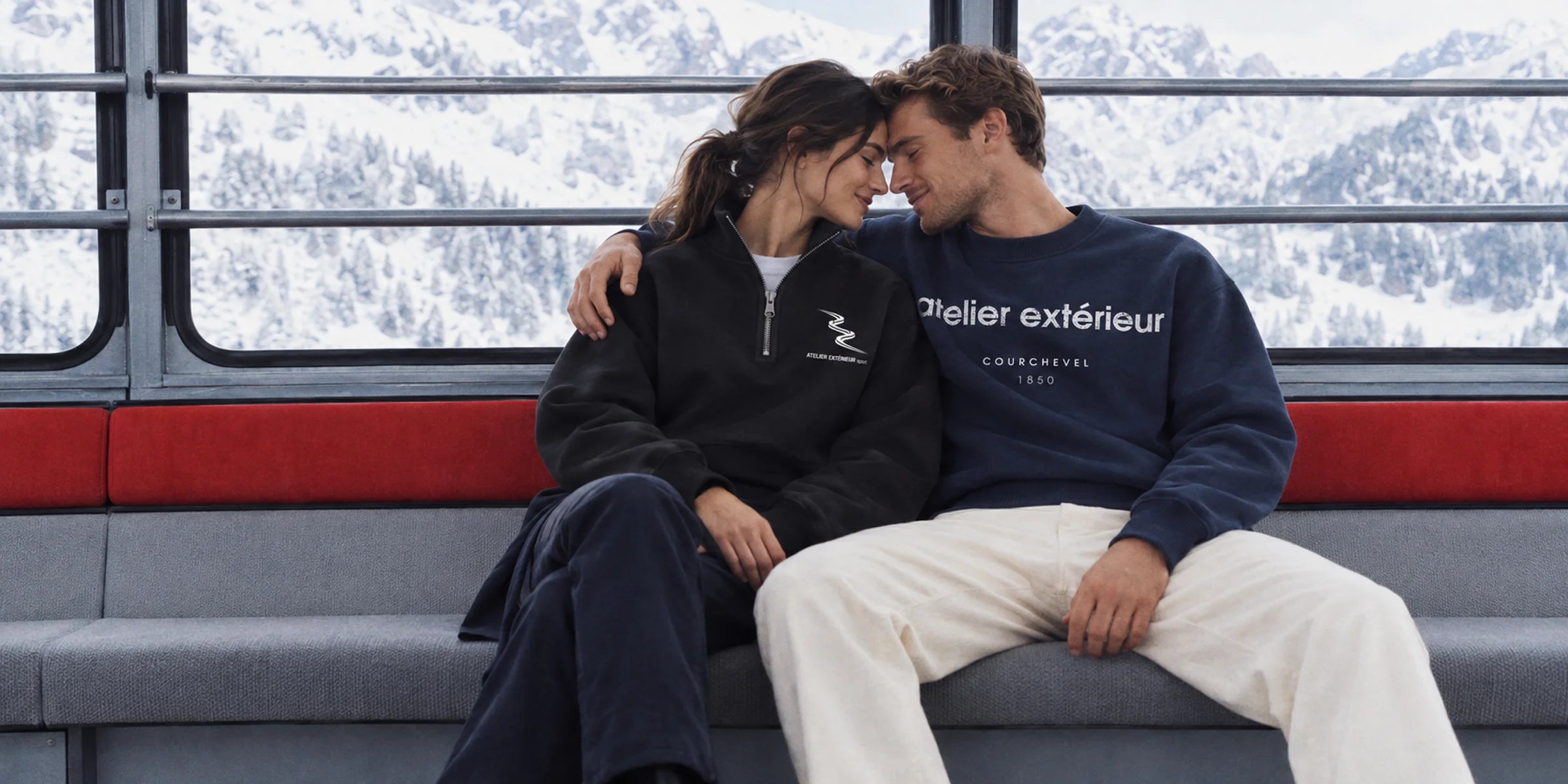 Couple in Atelier Extérieur quarter zip and Courchevel crewneck riding a gondola