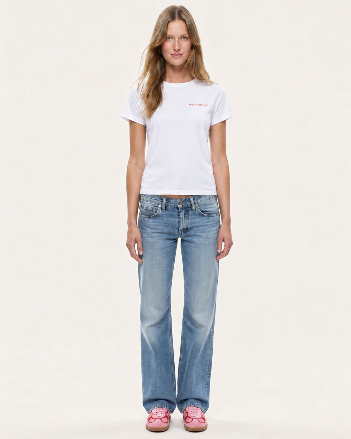 Model wearing the Champagne women's tee in white with straight-leg jeans, front view