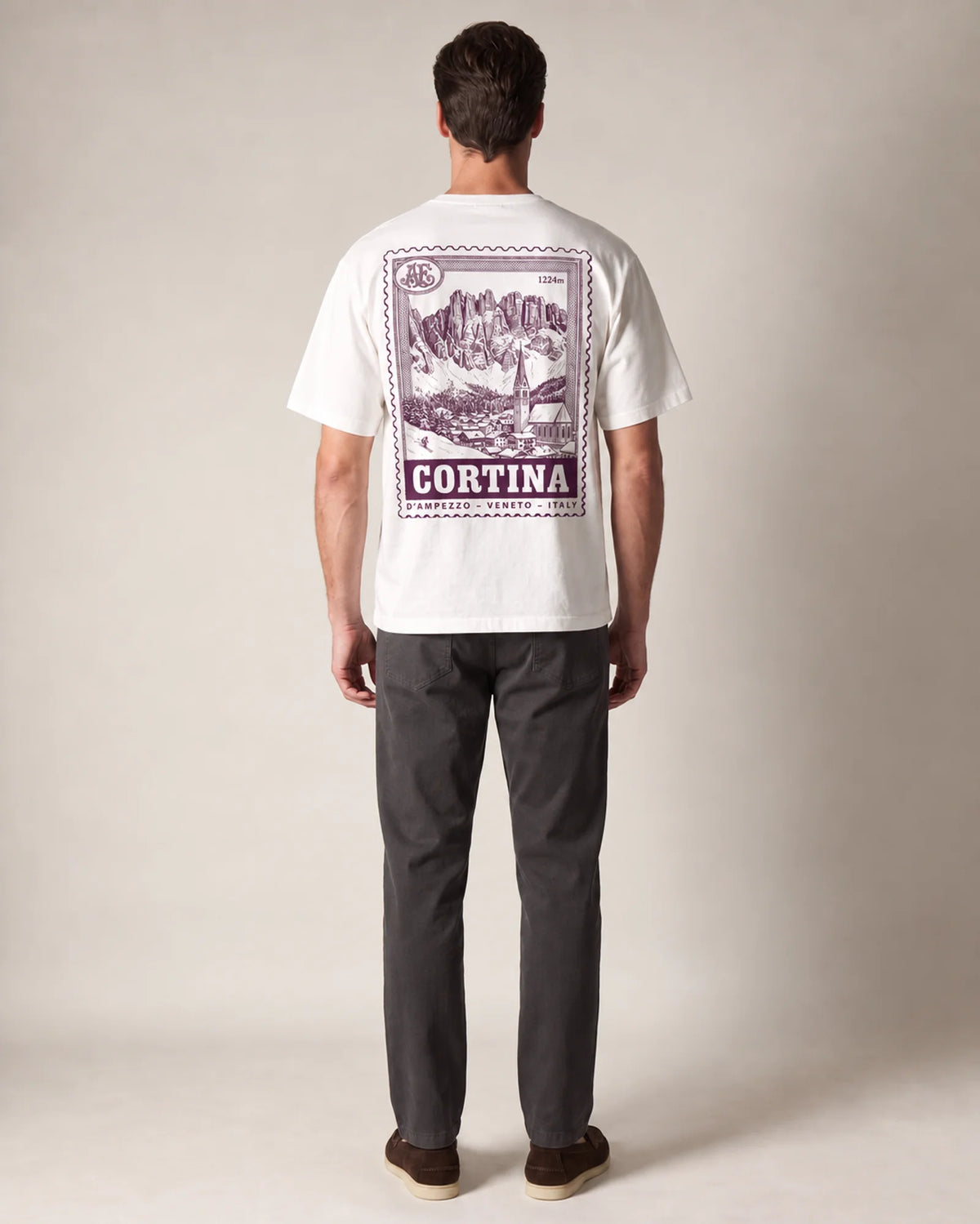 Model wearing the white Cortina tee in a studio, back view