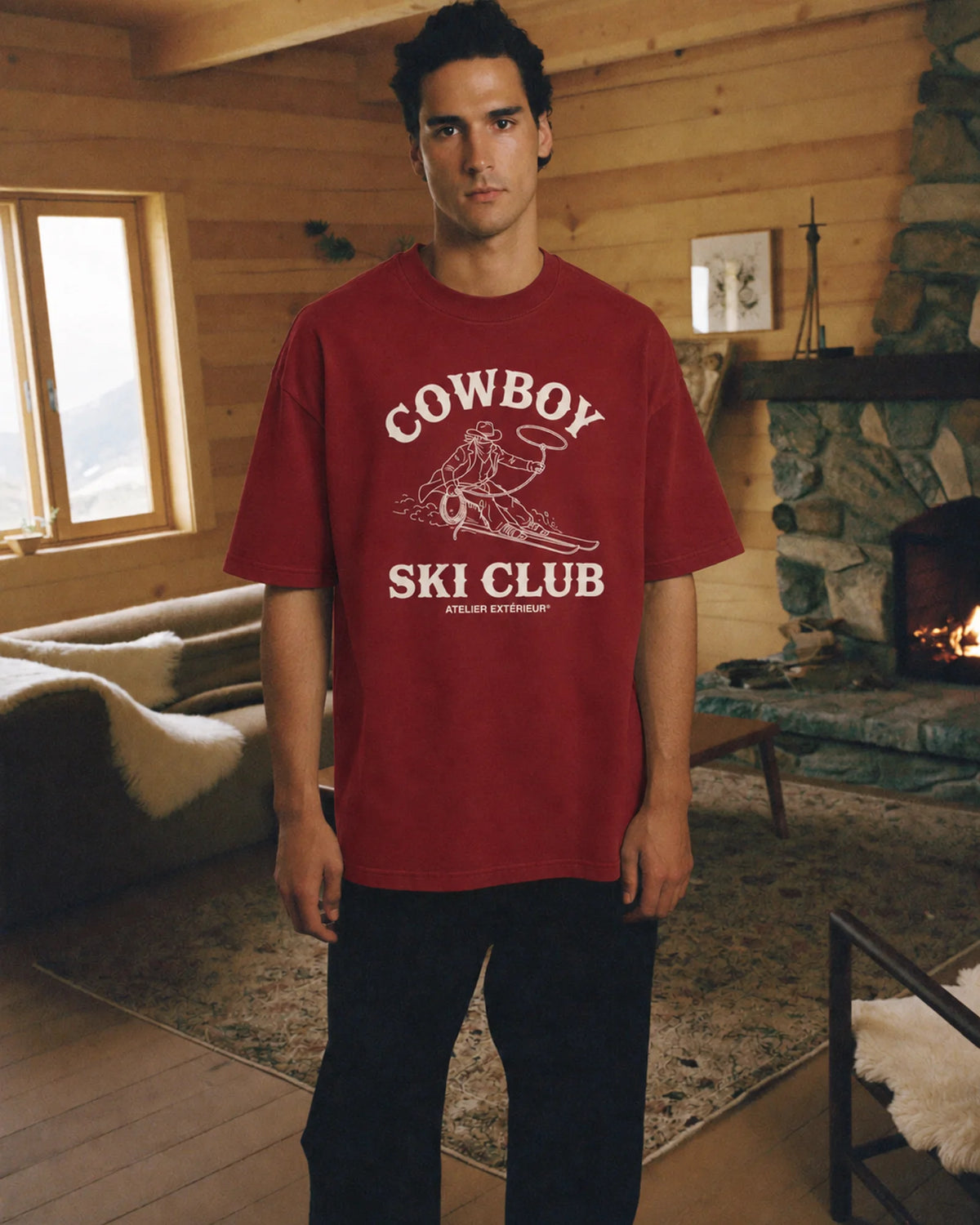 Man wearing the red Cowboy Ski Club tee outdoors, front view