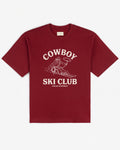 Deep red heavyweight cotton tee, front view, with a cream Cowboy Ski Club print of a lasso-swinging cowboy on skis