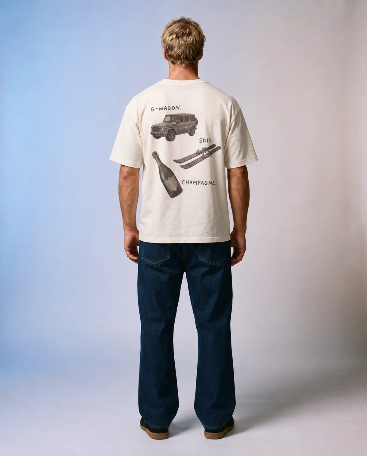 Model wearing the ecru Essentials tee in a studio, back view