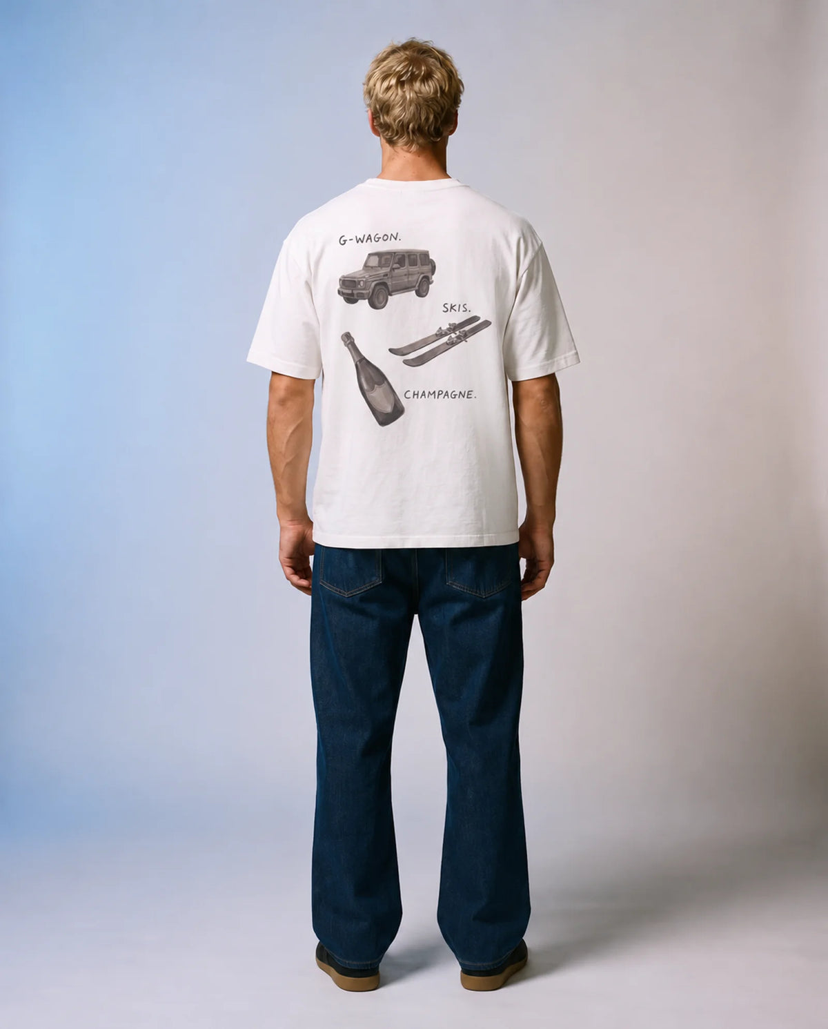 Model wearing the white Essentials tee in a studio, back view