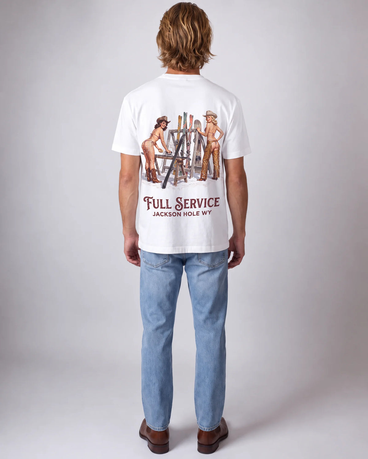 Model wearing the white Full Service tee in a studio, back view