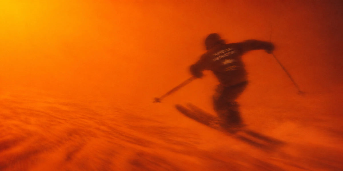 Skier in an Après Ski Instructor top at dusk, orange light