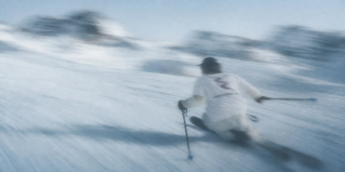 Skier in an Atelier Extérieur tee carving a turn