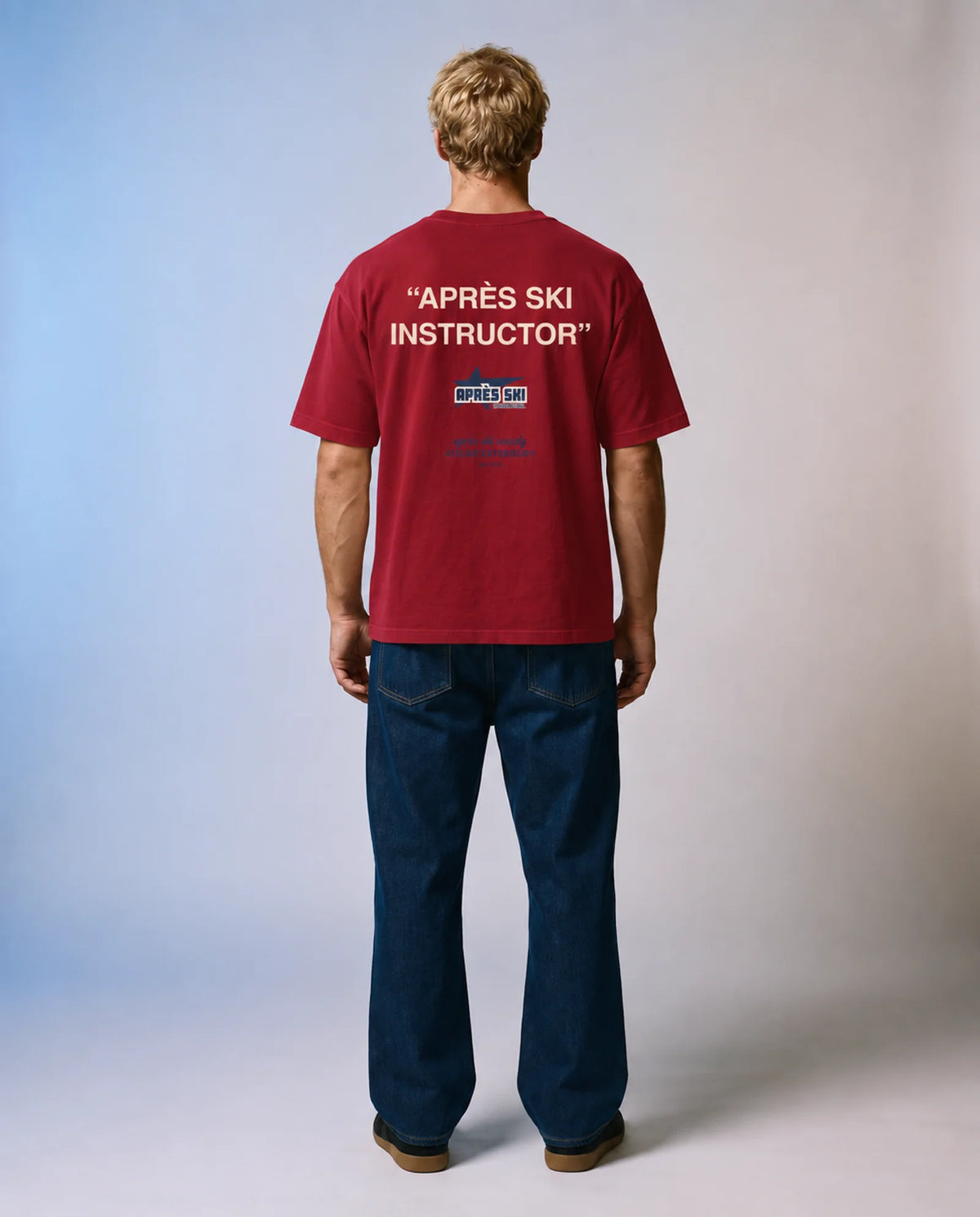 Studio model wearing the red Après Ski Instructor tee, back view