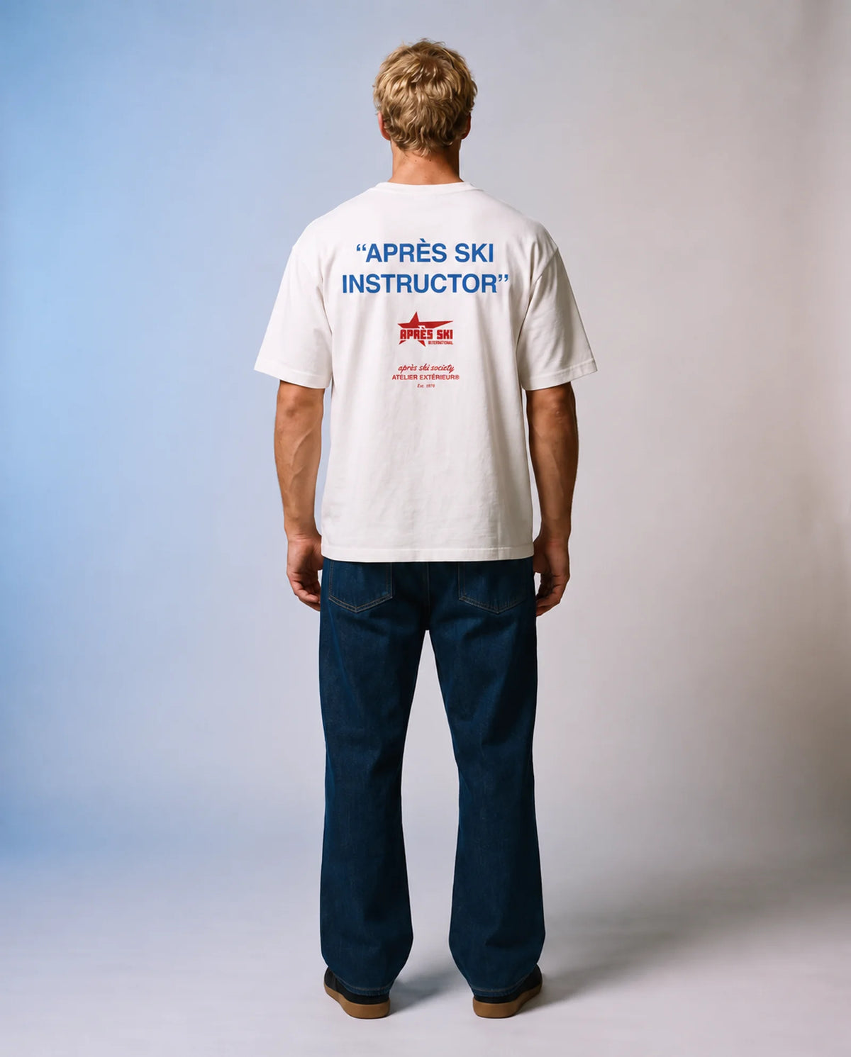 Studio model wearing the white Après Ski Instructor tee, back view