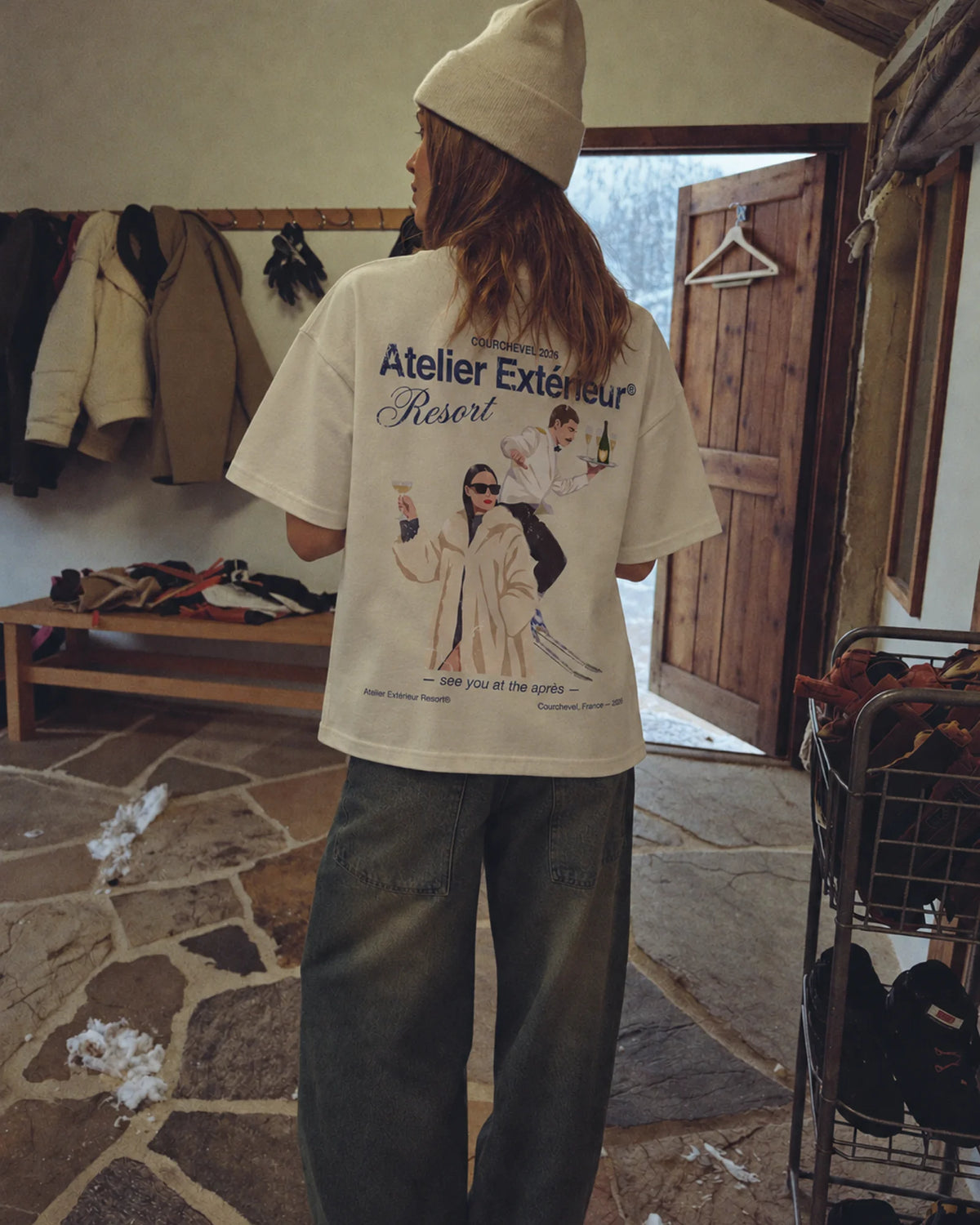 Woman wearing the ecru Resort tee outdoors, showing the back print