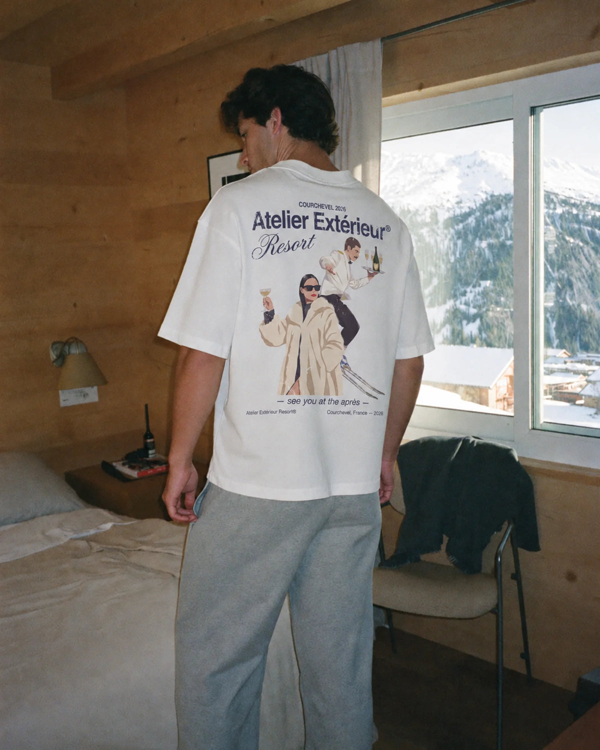 Man wearing the white Resort tee outdoors, showing the back print