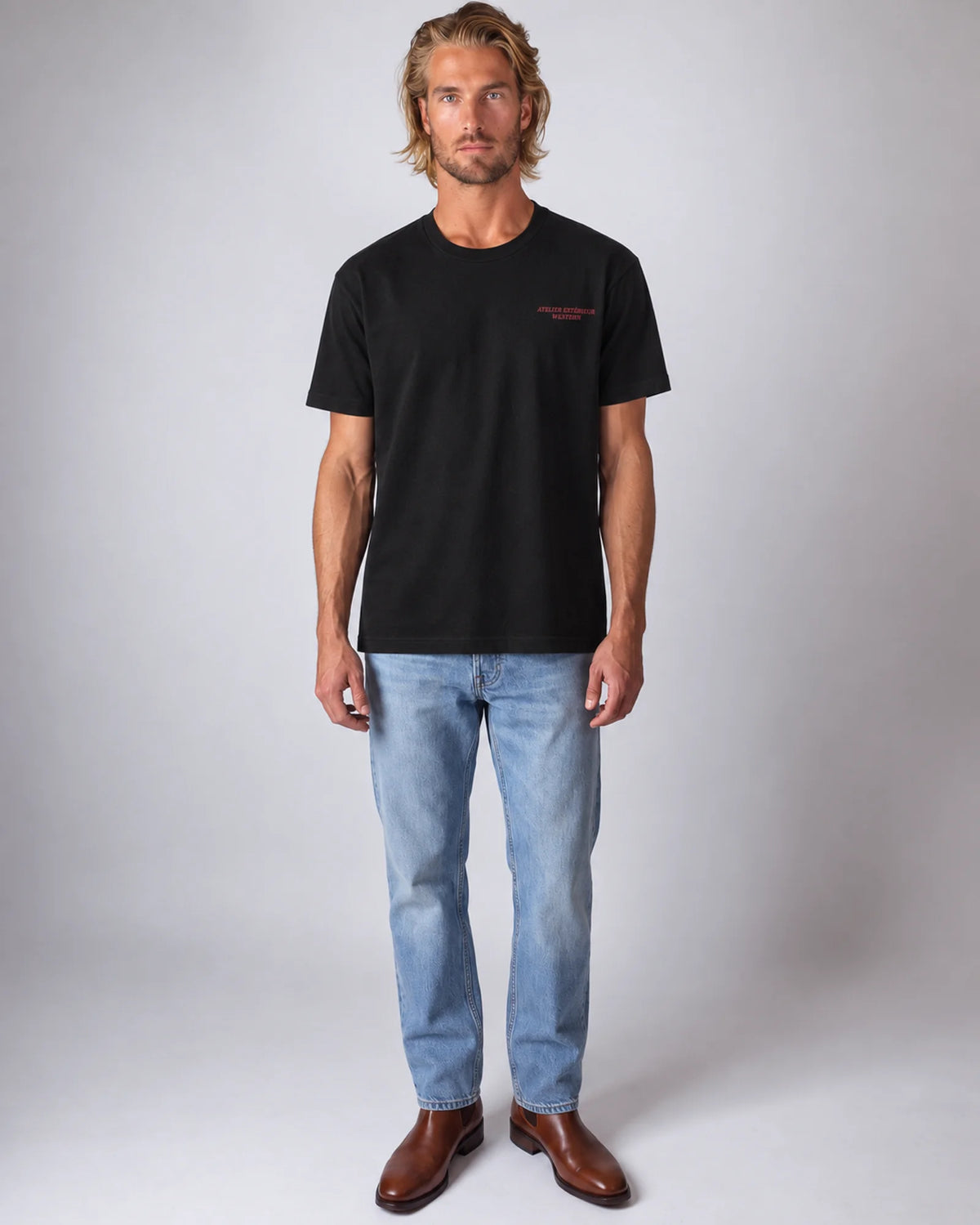 Model wearing the black Rodeo Downhill tee in a studio, front view