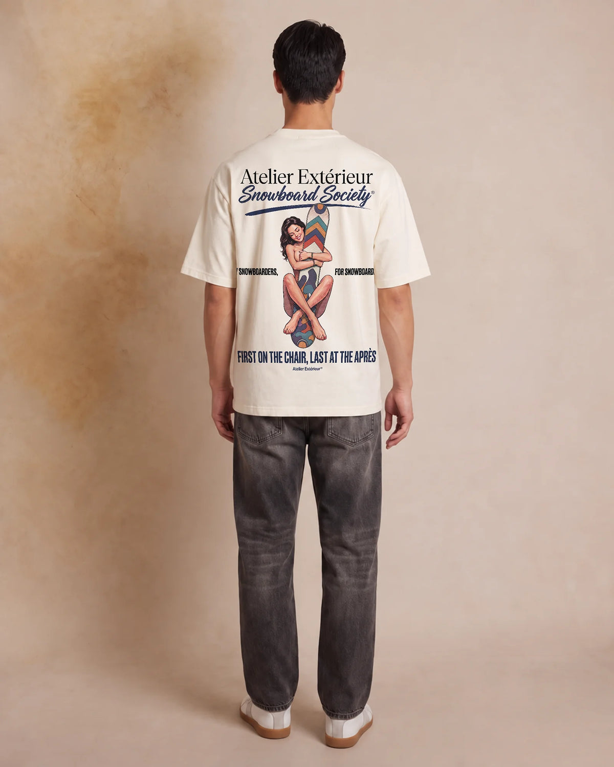 Studio model wearing the ecru Snowboard Society tee, back view