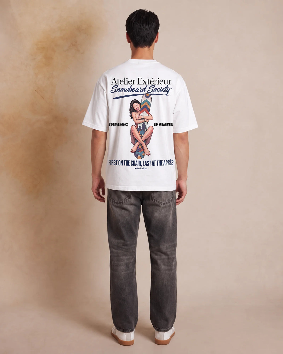 Studio model wearing the white Snowboard Society tee, back view