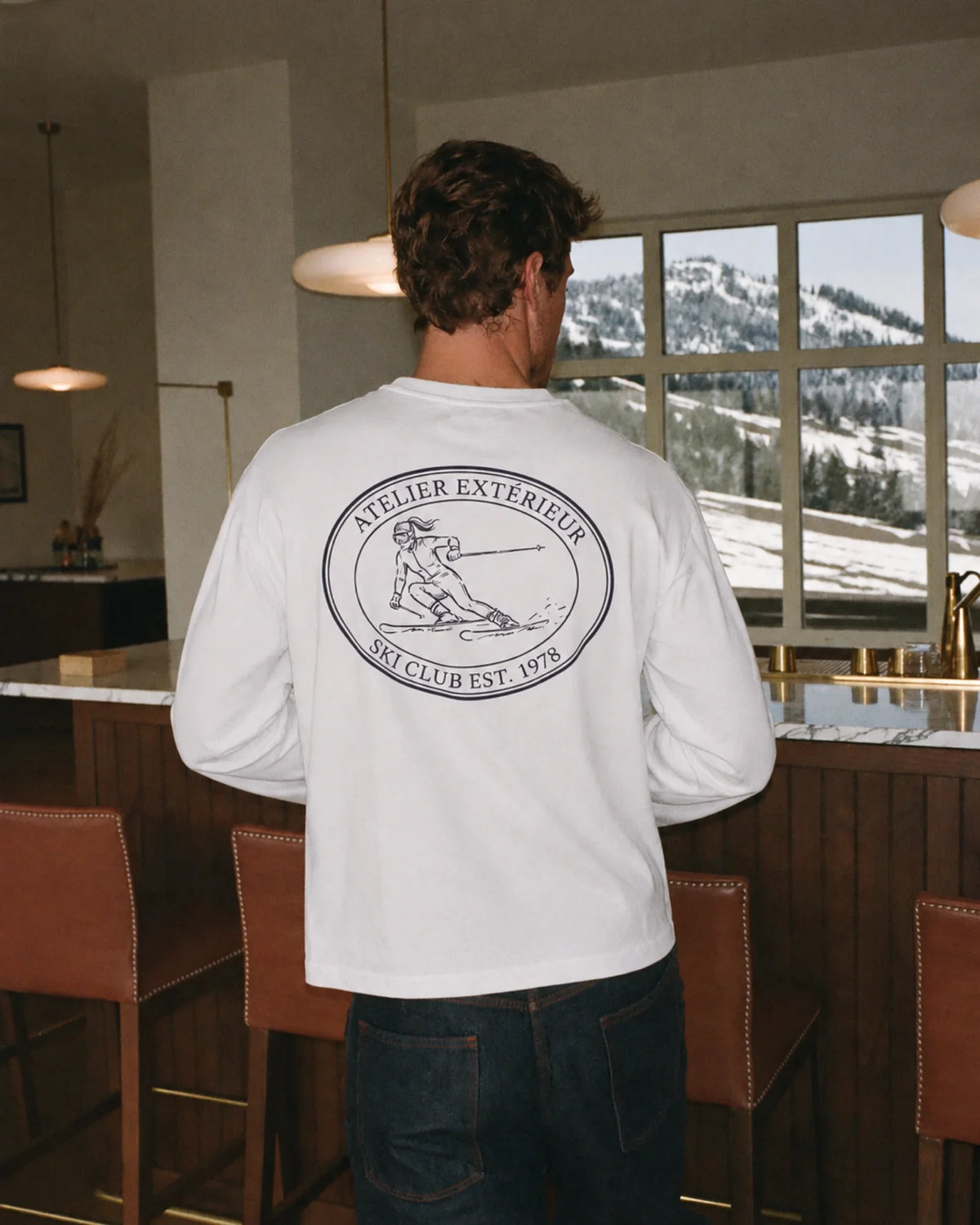 Man wearing the Ski Club Long Sleeve Tee in white, on location