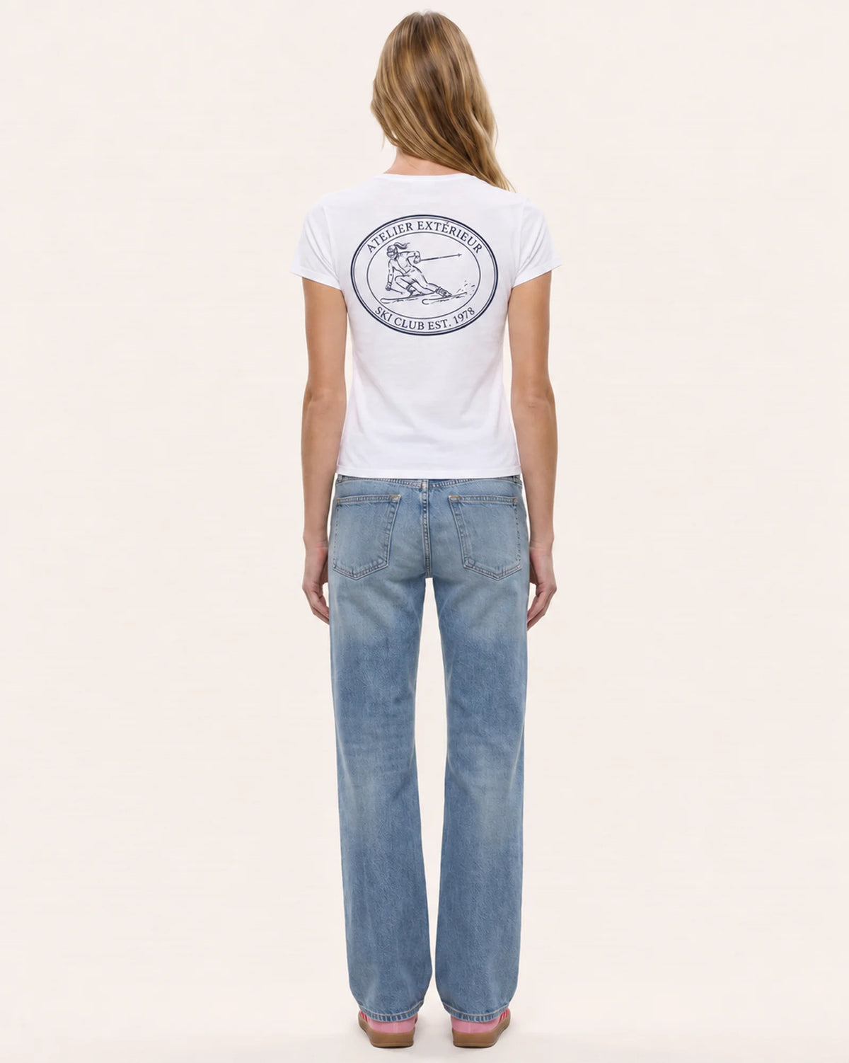 Model wearing the Ski Club women's tee in white, back view, showing the oval emblem