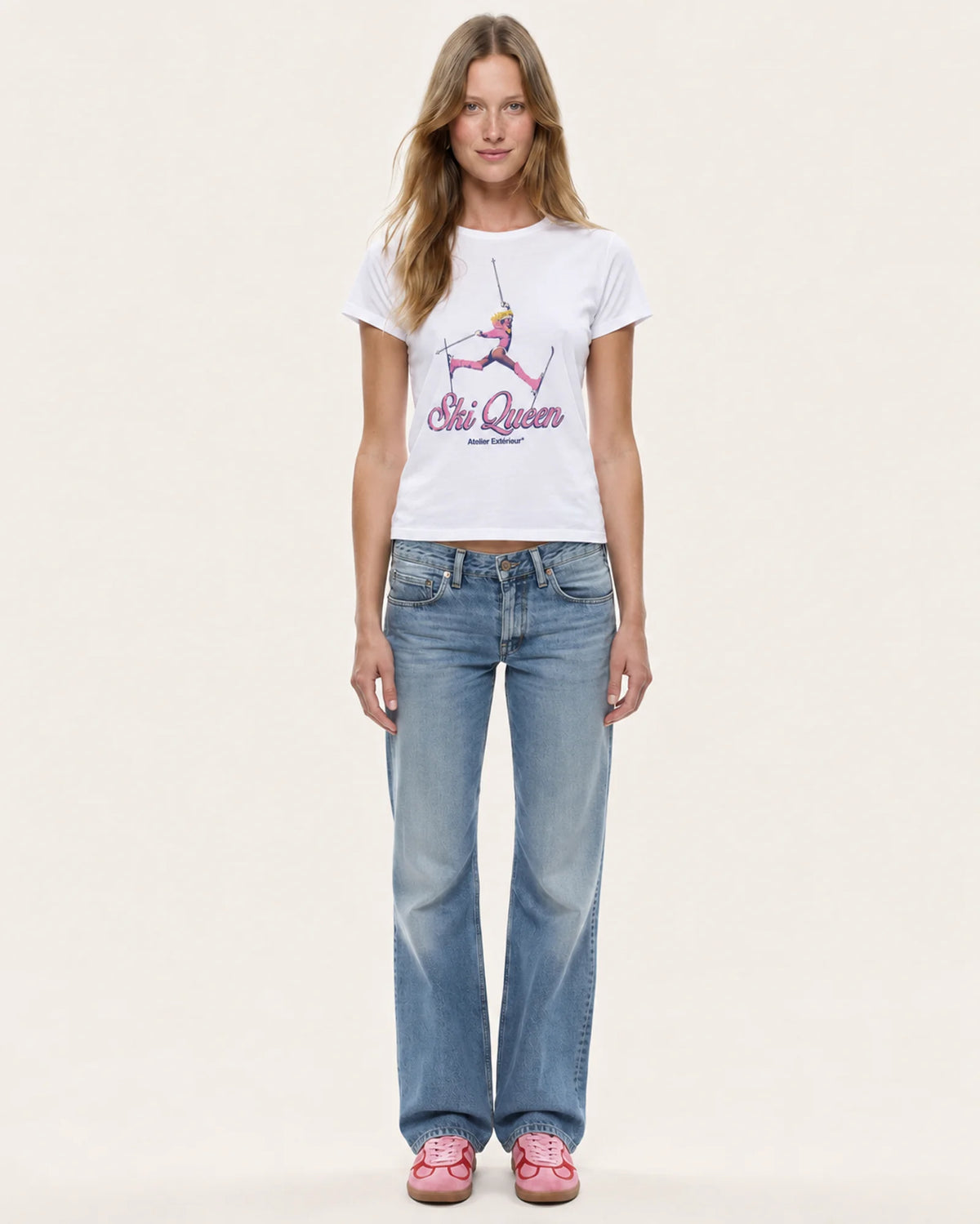Model wearing the Ski Queen women's tee in white with straight-leg jeans, front view