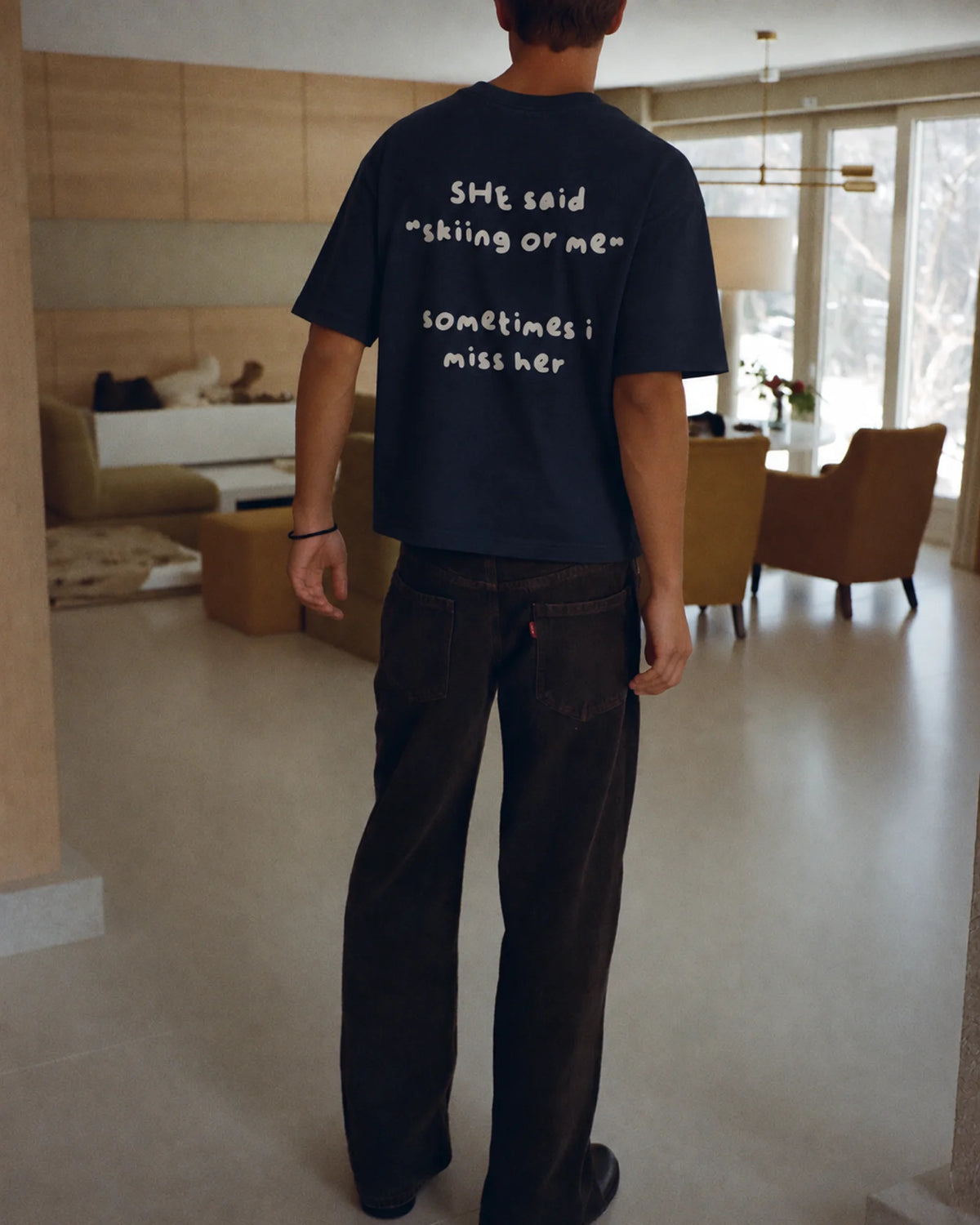 Man wearing the Skiing or Me Tee in navy, on location