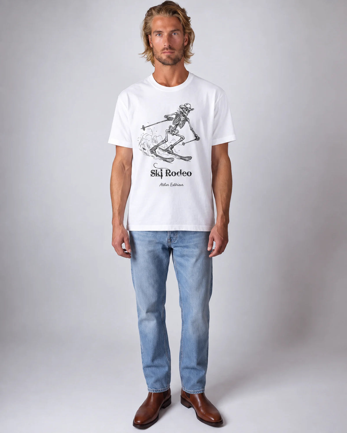 Model wearing the white Ski Rodeo tee in a studio, front view