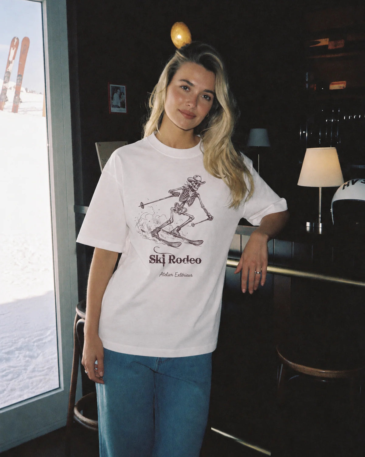 Woman wearing the white Ski Rodeo tee outdoors, front view