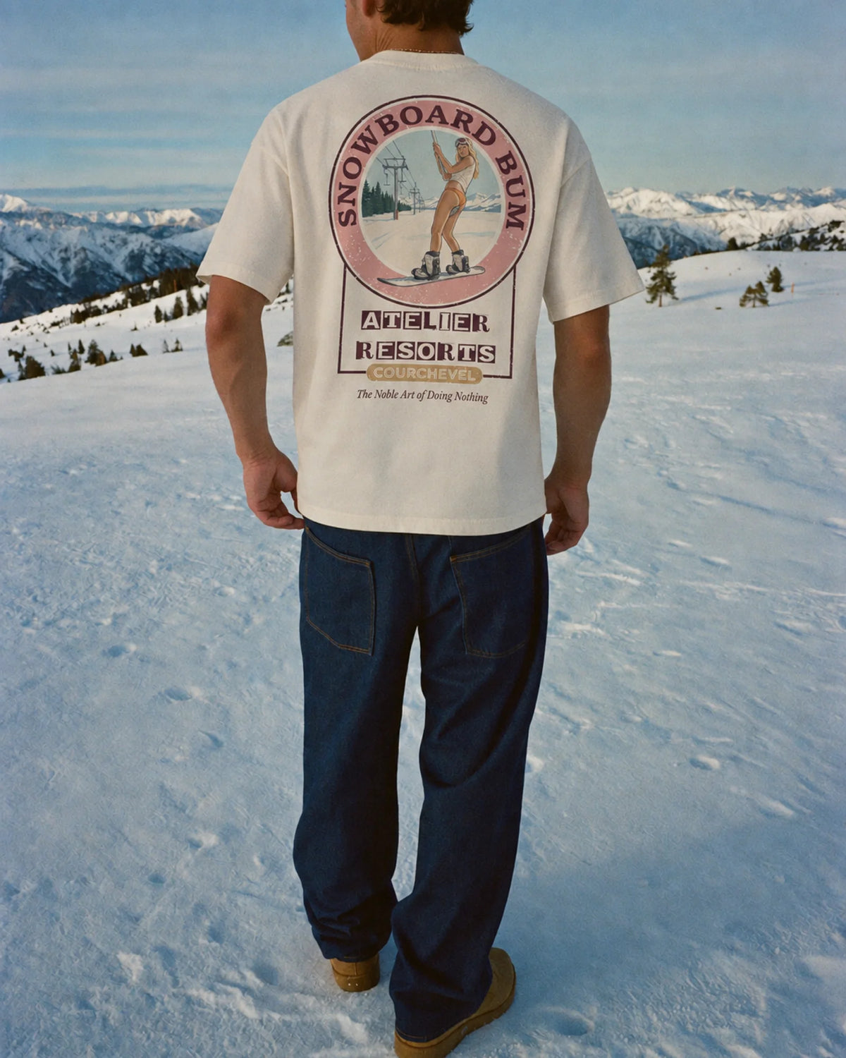 Man wearing the Snowboard Bum Tee in ecru, on location