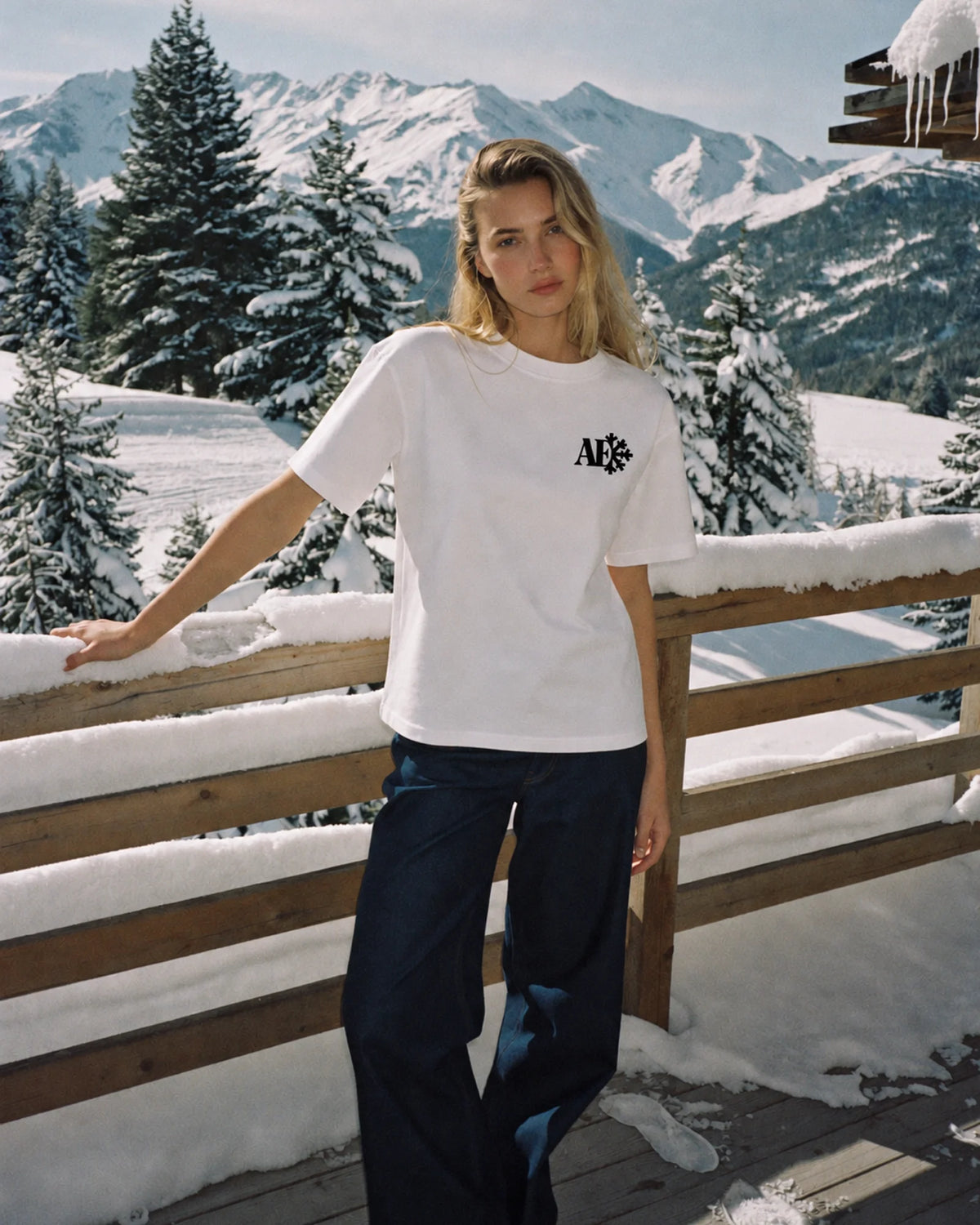 Woman wearing the white Snowflake tee in the snow, front print visible
