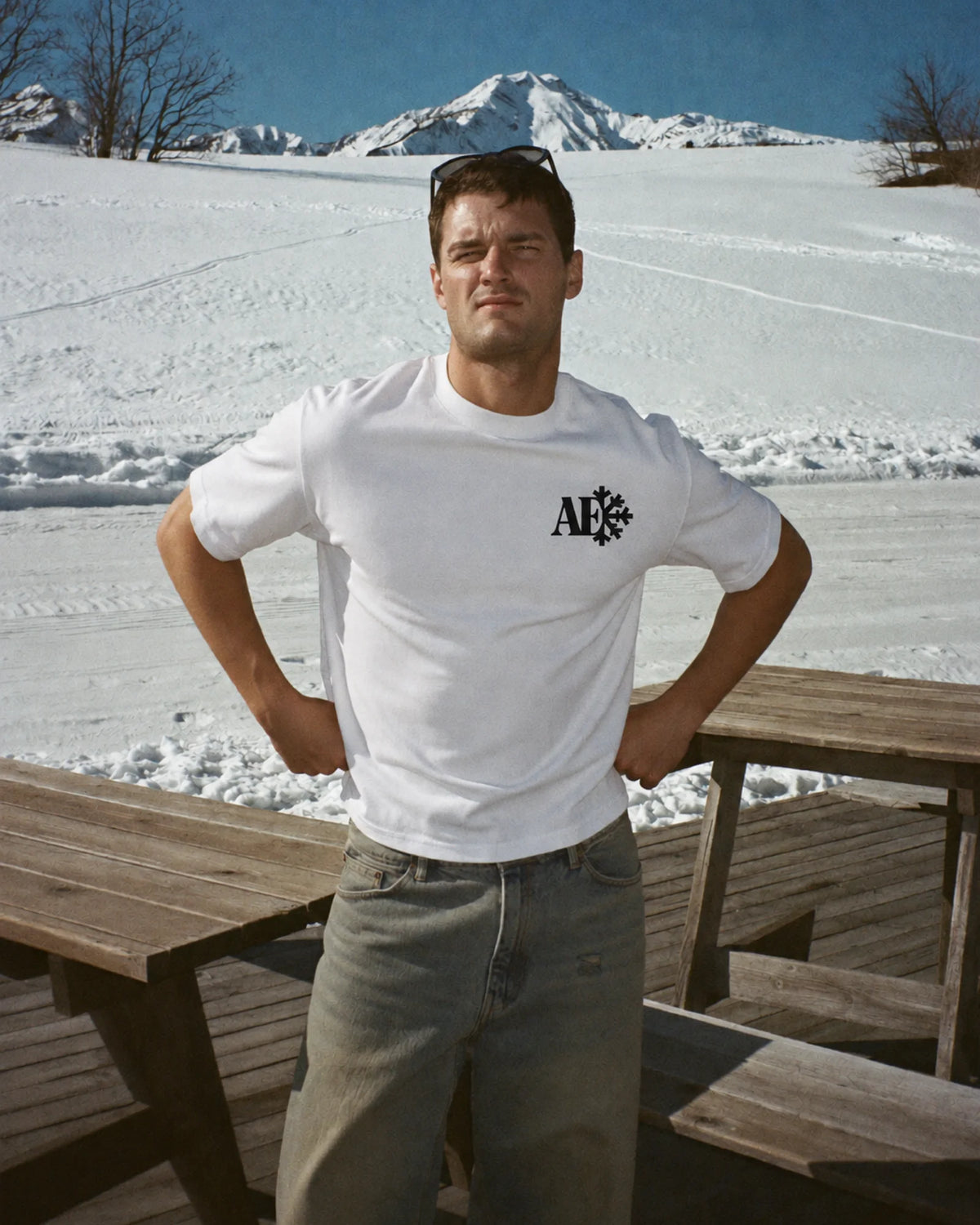 Man wearing the white Snowflake tee in the snow, front print visible
