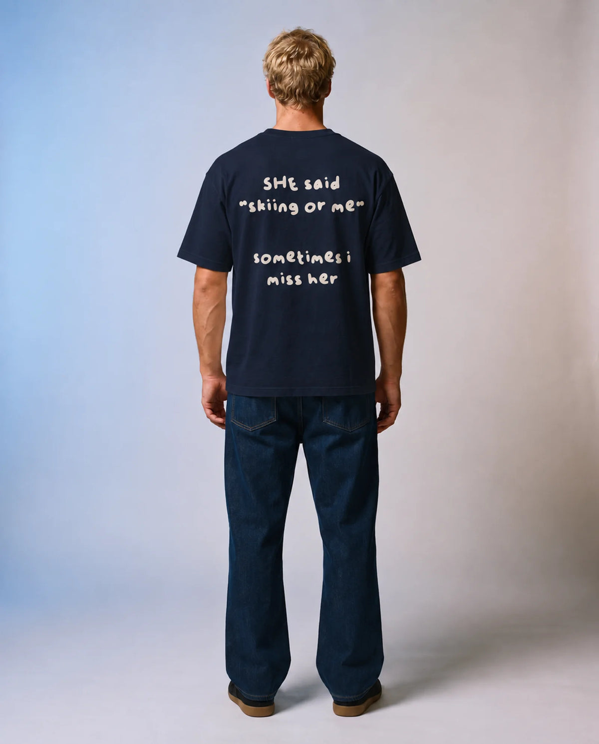 Studio model wearing the navy Skiing or Me tee, back view