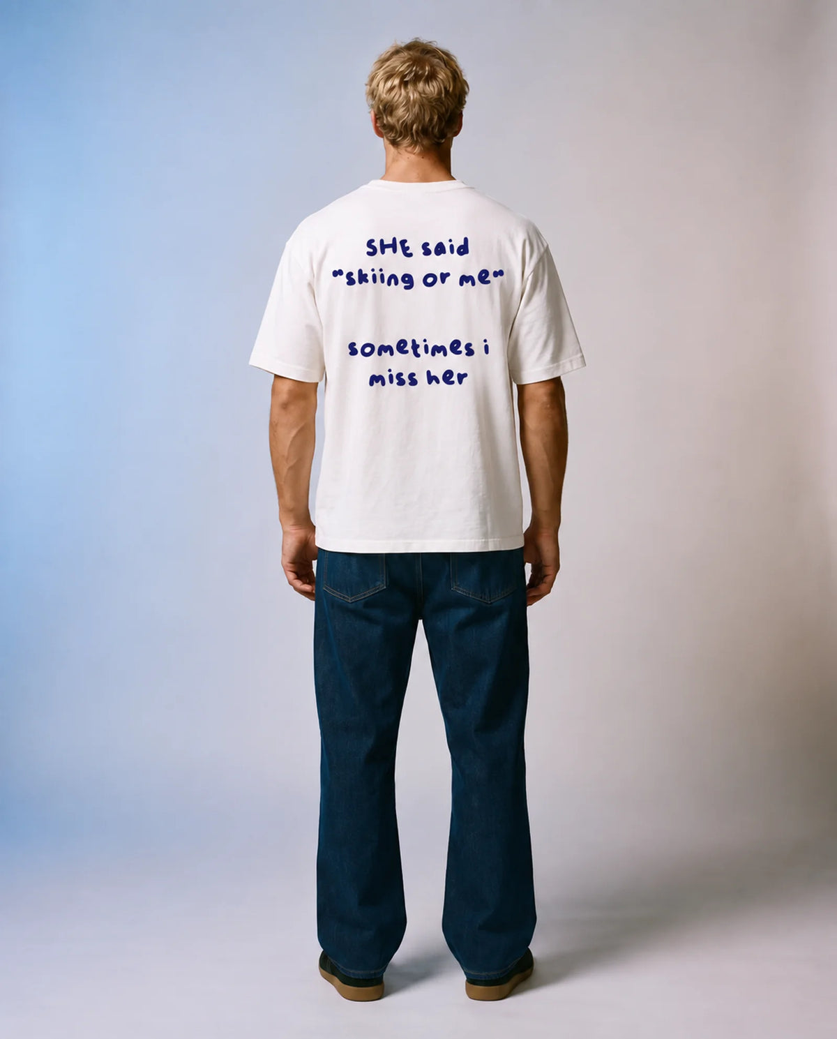 Studio model wearing the white Skiing or Me tee, back view