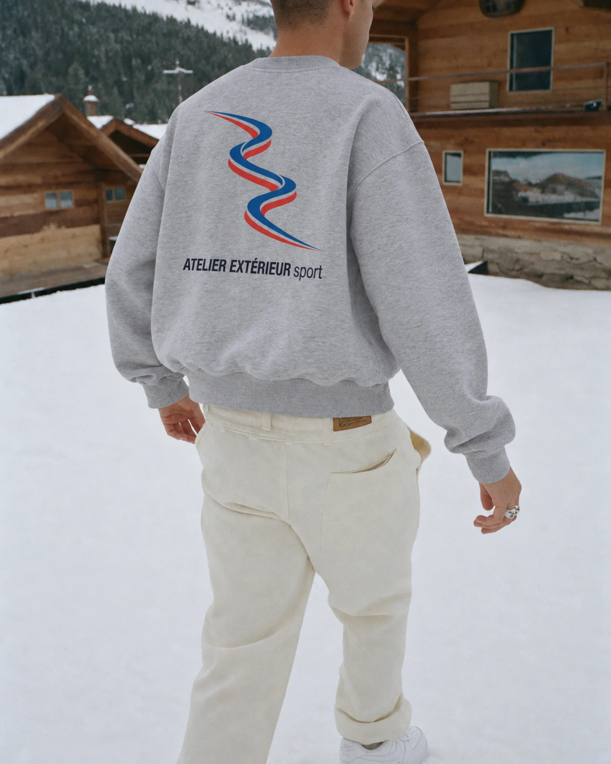 Man wearing the Sport Crewneck in heather gray, on location