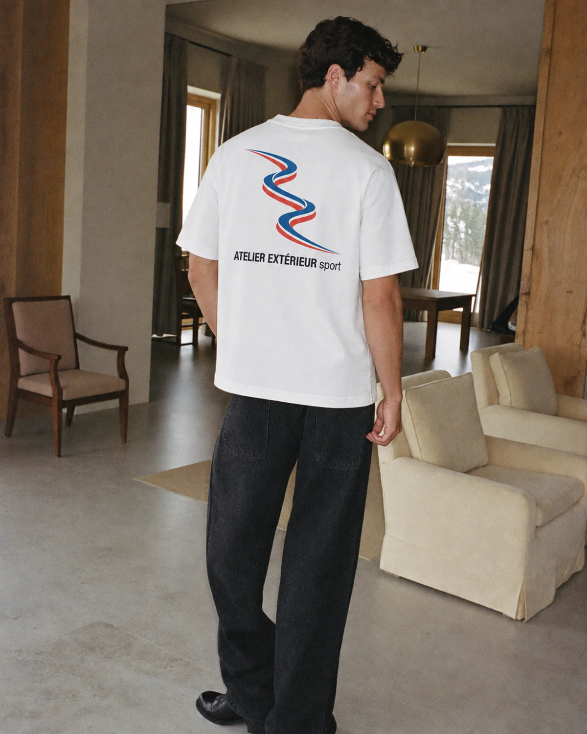 Man wearing the Sport Tee in white, on location