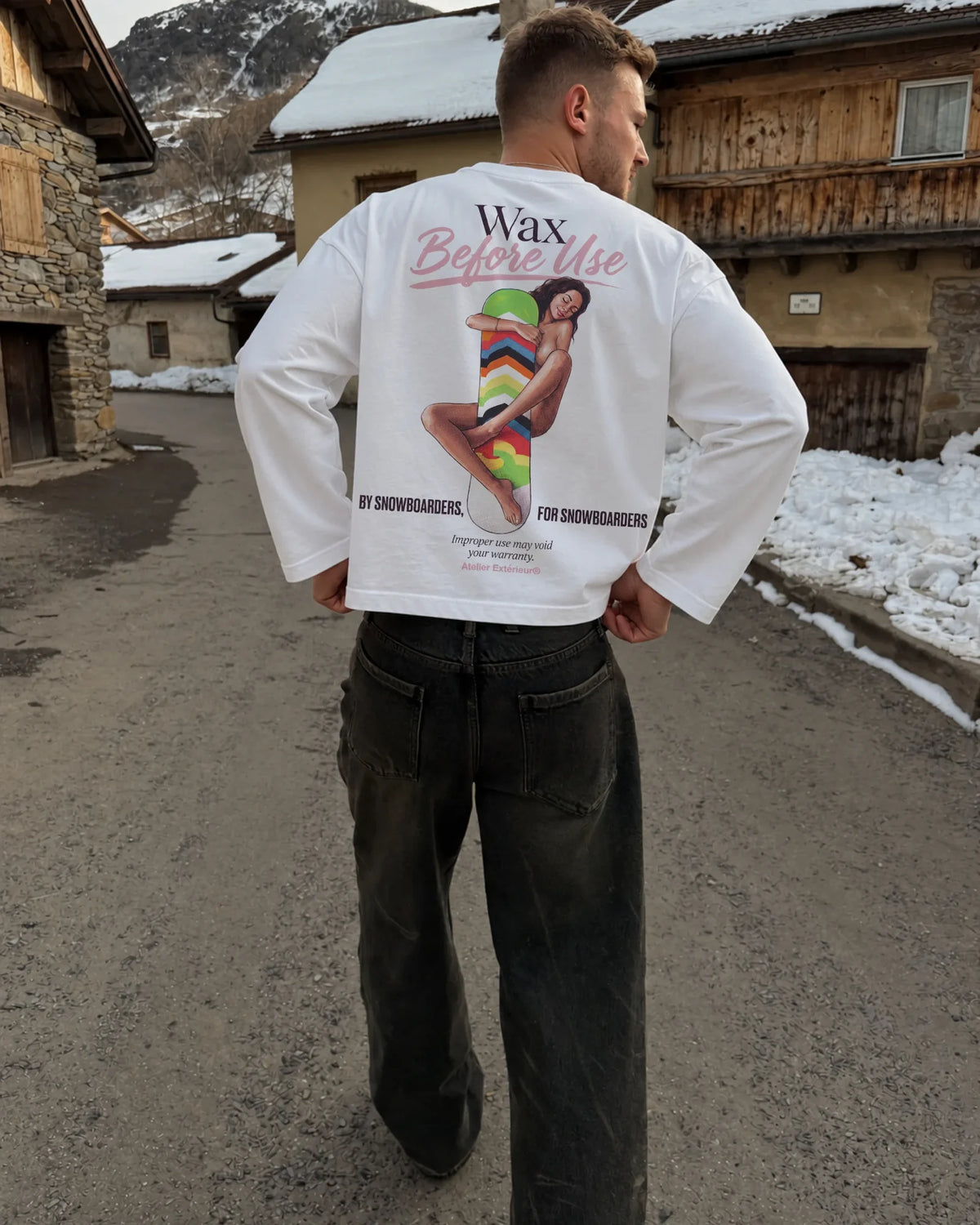 Man wearing the Wax Before Use Long Sleeve Tee in white, on location