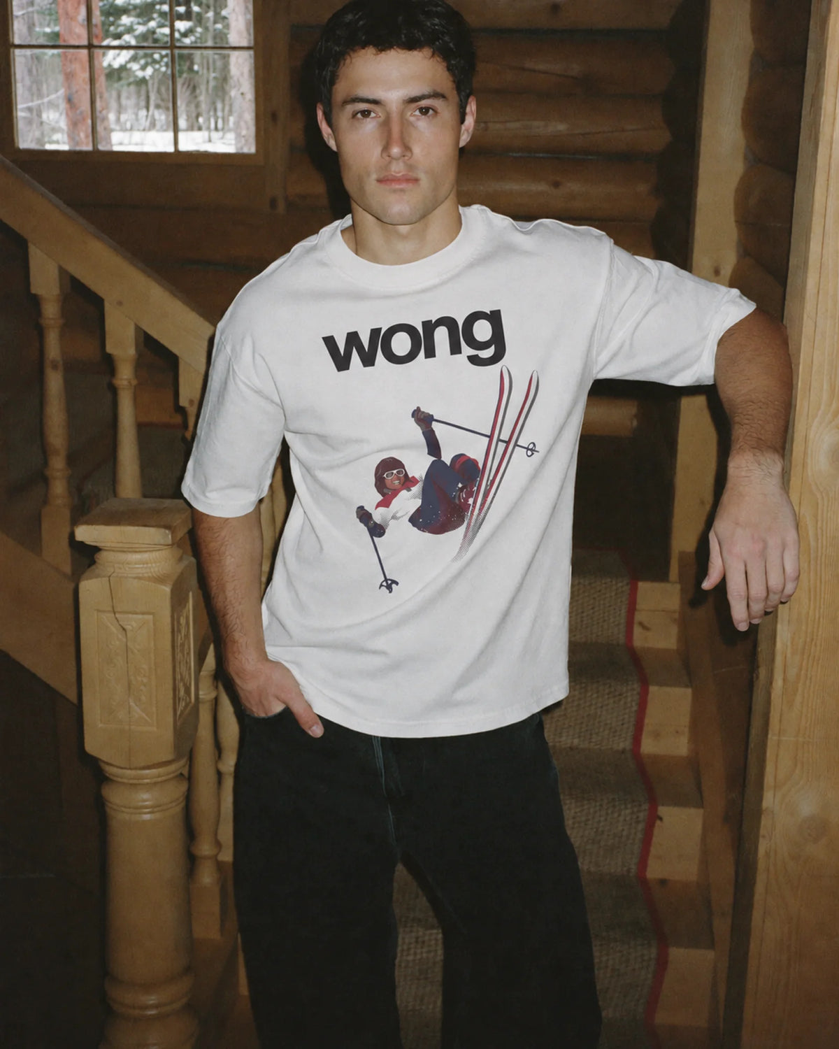 Man wearing the white Wong tee in the snow, front print visible
