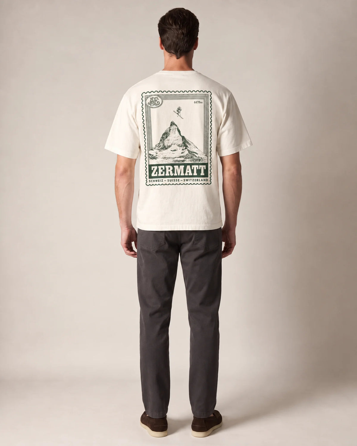 Studio model wearing the ecru Zermatt Stamp tee, back view